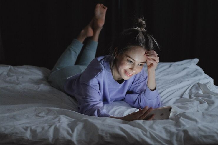 Ragazza sul letto al cellulare