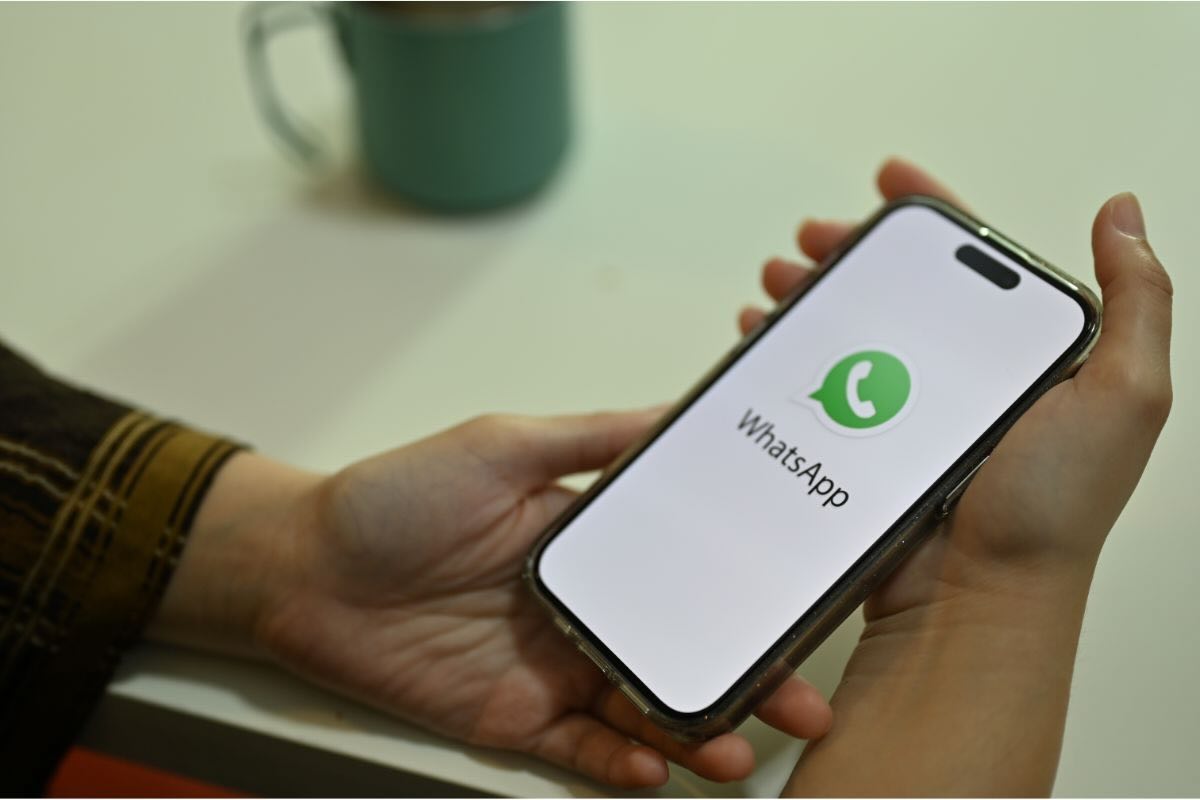 Smartphone in mano con logo Whatsapp
