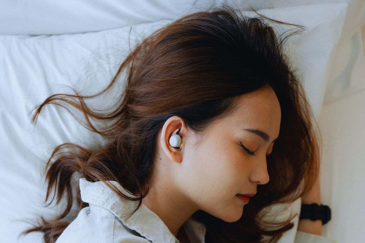 Ragazza che dorme con auricolari nelle orecchie