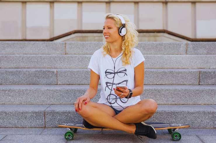 Ragazza che ascolta musica in strada con le cuffie