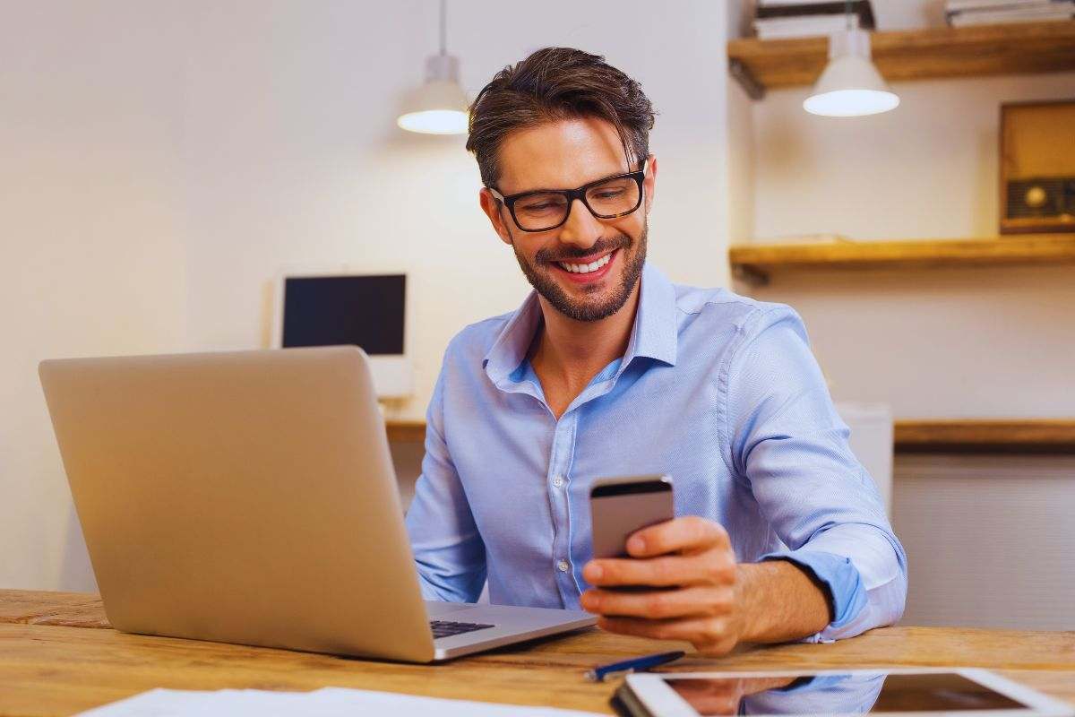 Uomo sorridente alla scrivania