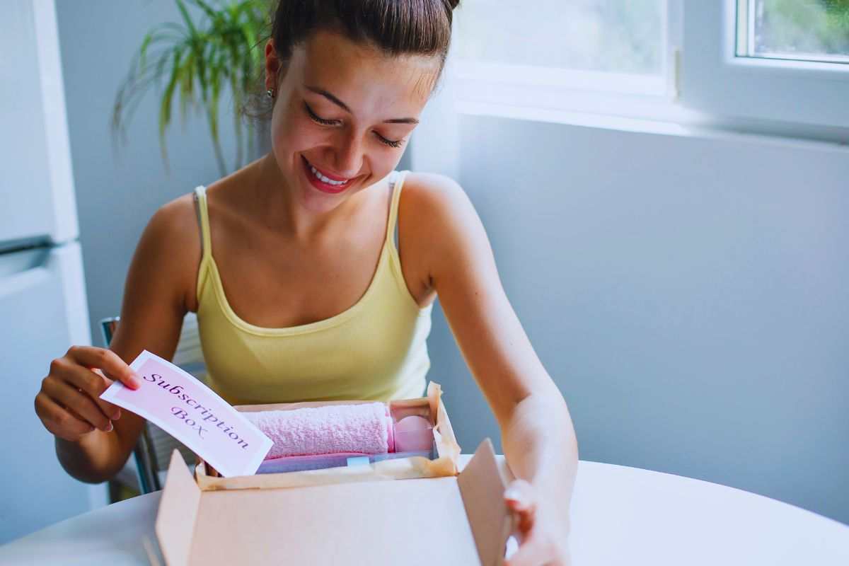 Ragazza sorridente che scarta un pacco