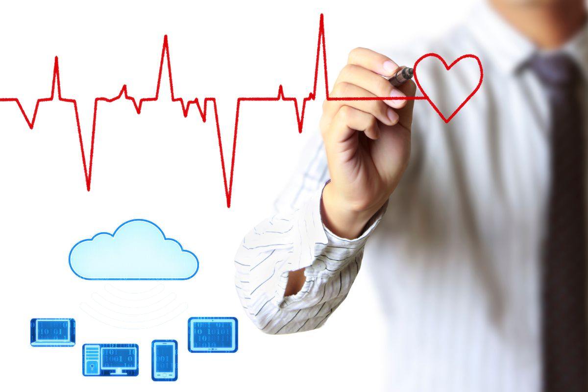 Uomo che disegna un tracciato cardiaco e immagini di device tecnologici collegati da cloud