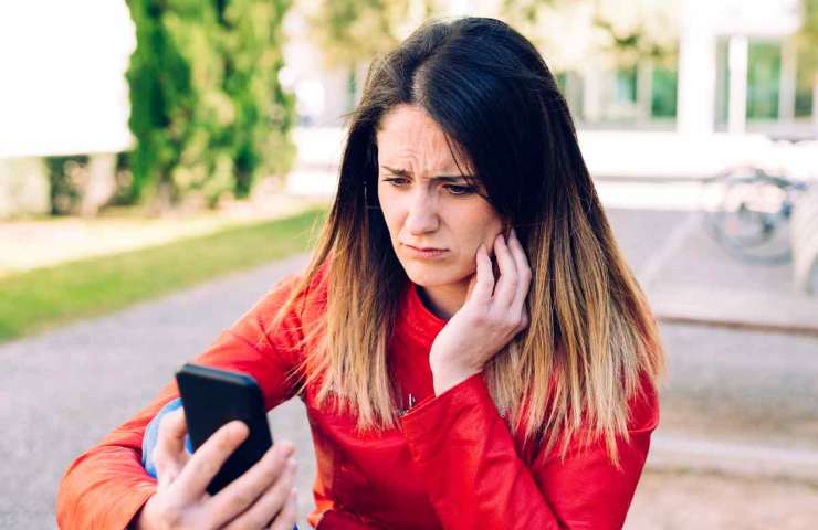 donna dubbiosa con telefono