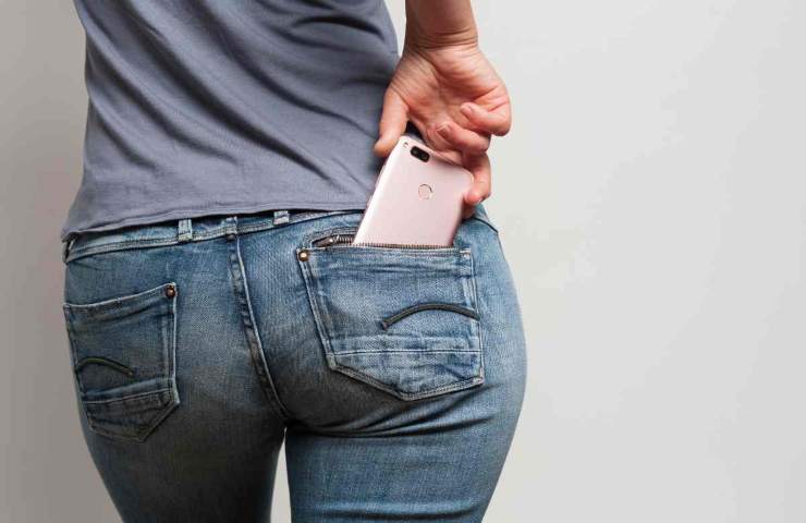 mano che prende telefono in tasca