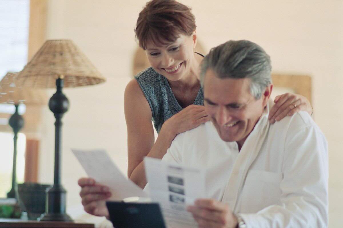 Coppia legge dei documenti, entrambi sono felici