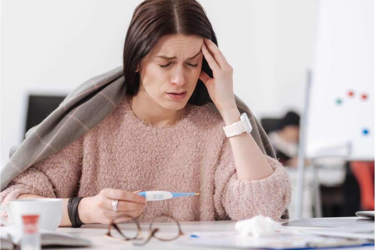 Donna malata seduta alla scrivania