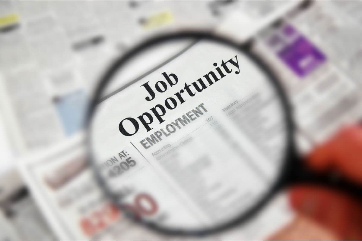 Lente ingrandimento su giornale con scritto "Job Opportunity"
