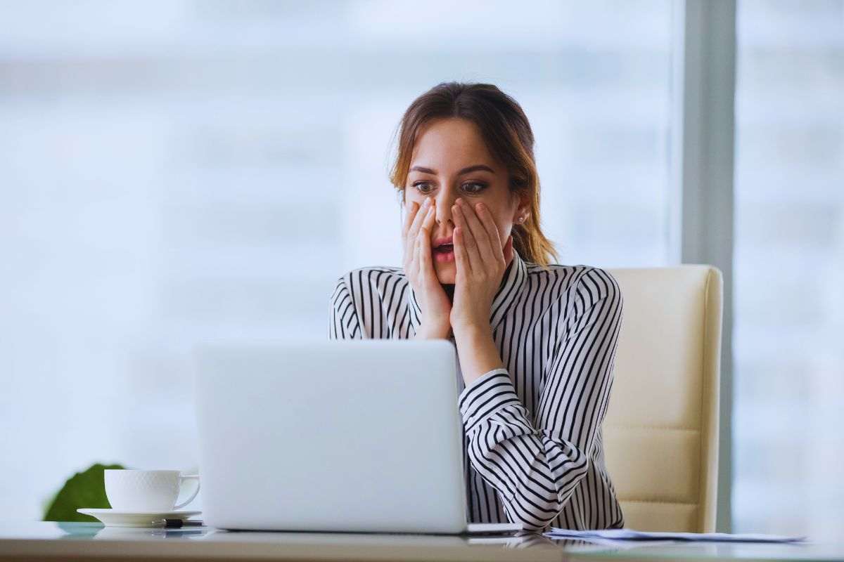 Donna scioccata davanti a PC