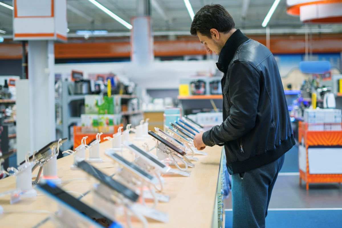Ragazzo sceglie telefono da comprare