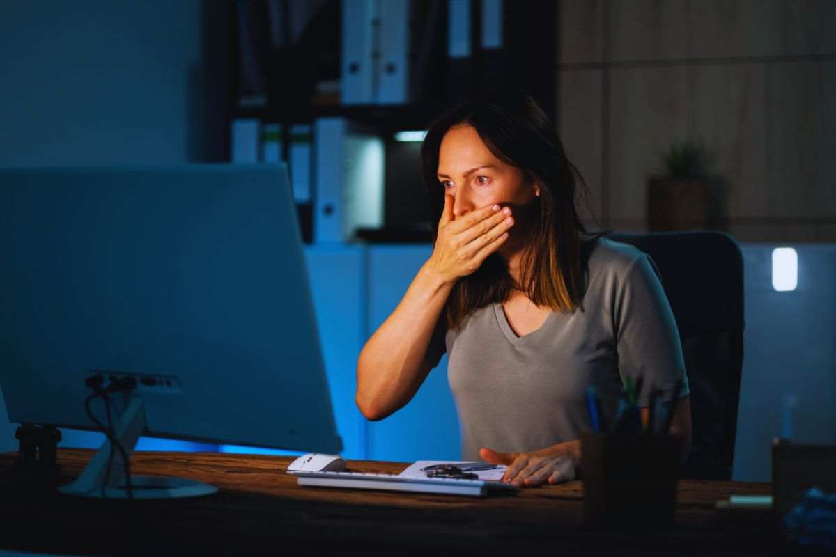 Donna preoccupata da ciò che vede su schermo