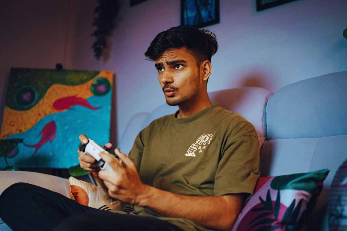 Ragazzo che gioca alla PS5 da divano