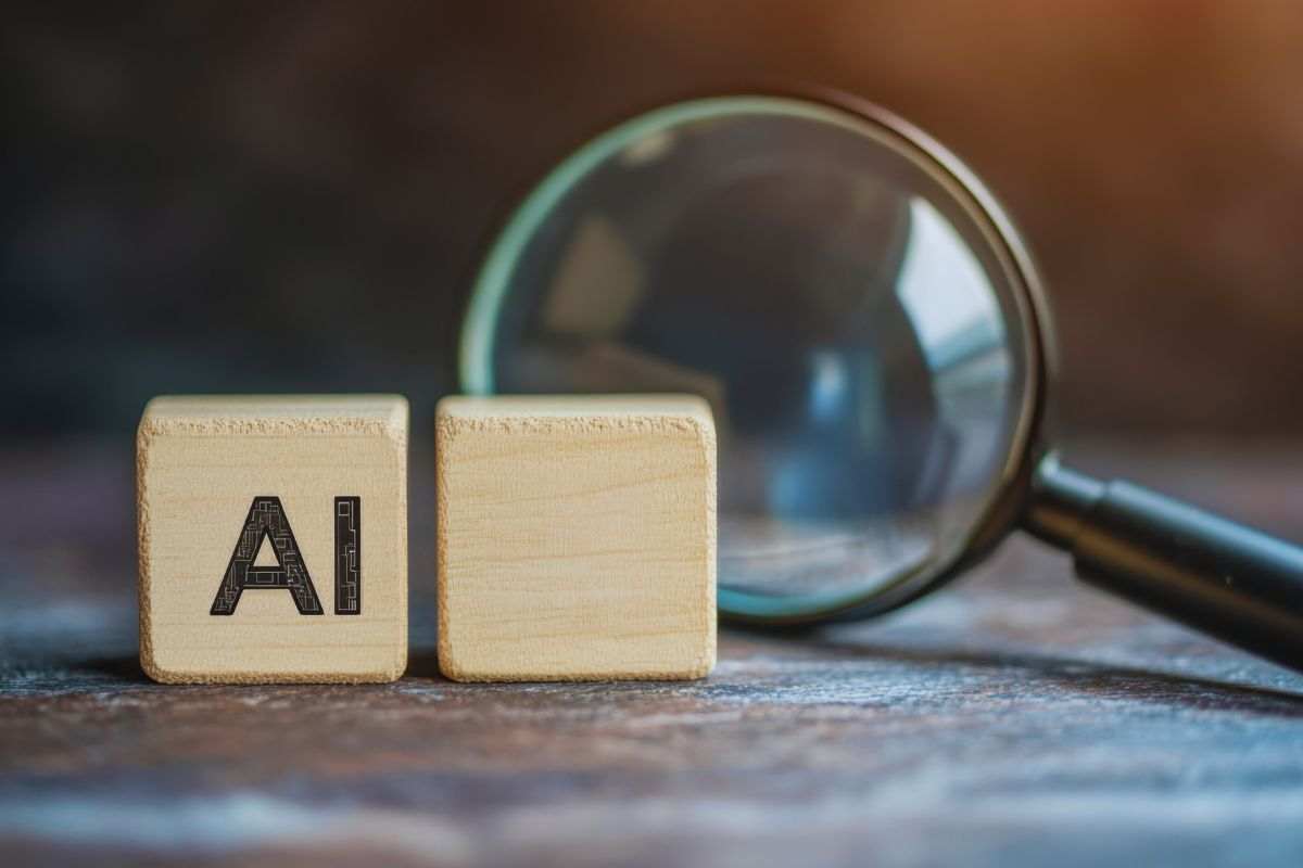 Lente d'ingrandimento e dadi di legno con su scritto "AI"