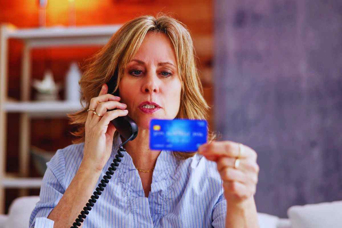 Donna che detta numero carta per telefono