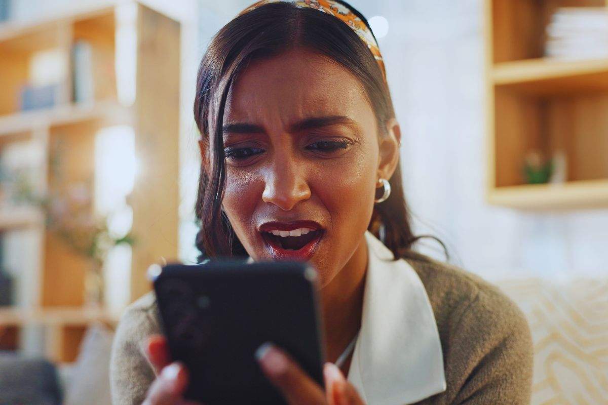 Ragazza con espressione preoccupata mentre utilizza lo smartphone