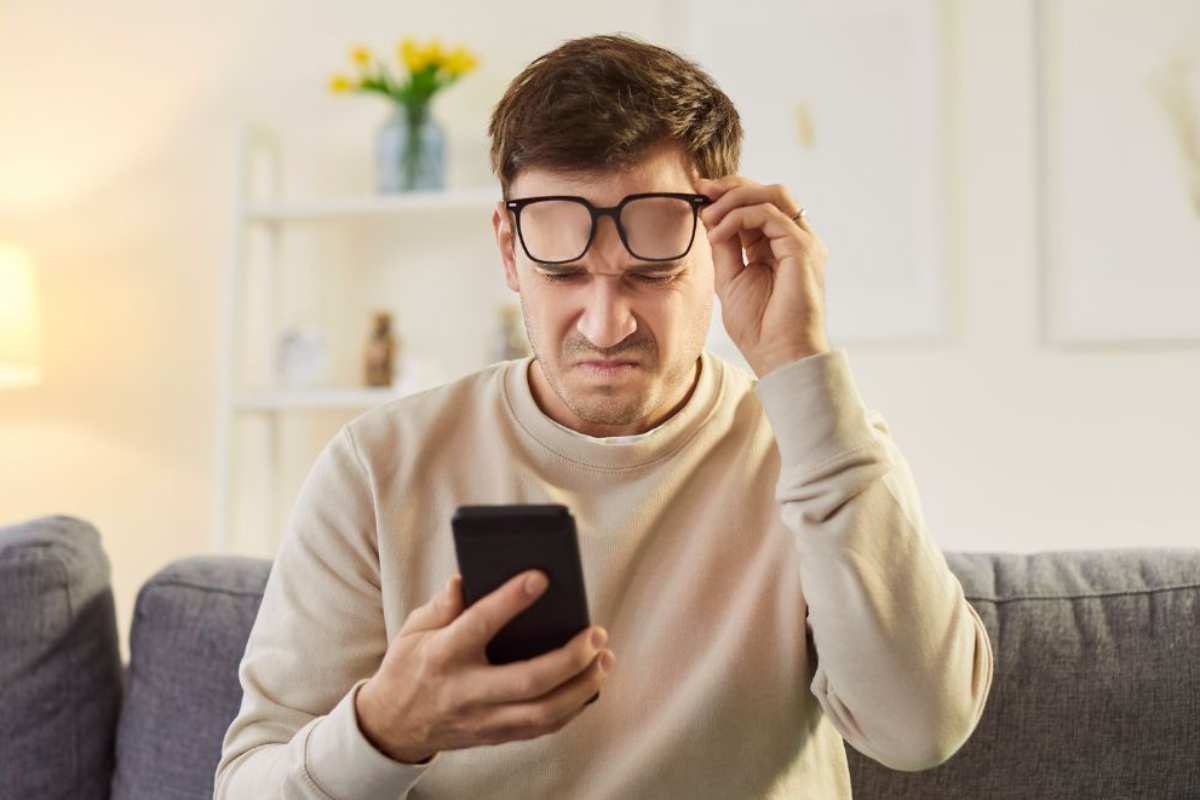 Persona che non riesce a leggere ciò che gli è spuntato sullo smartphone