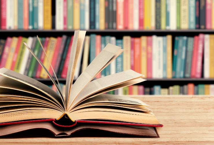 libri aperti e scaffale di libri