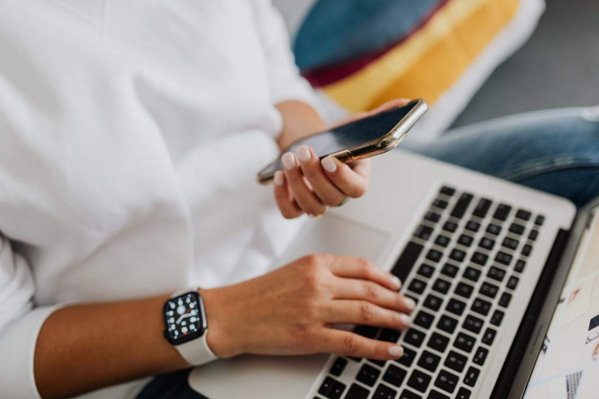 Donna con smartphone e laptop in mano