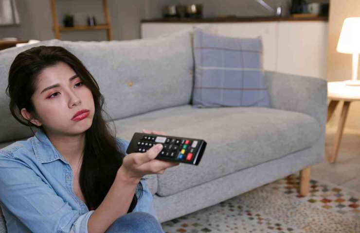 donna triste con il telecomando