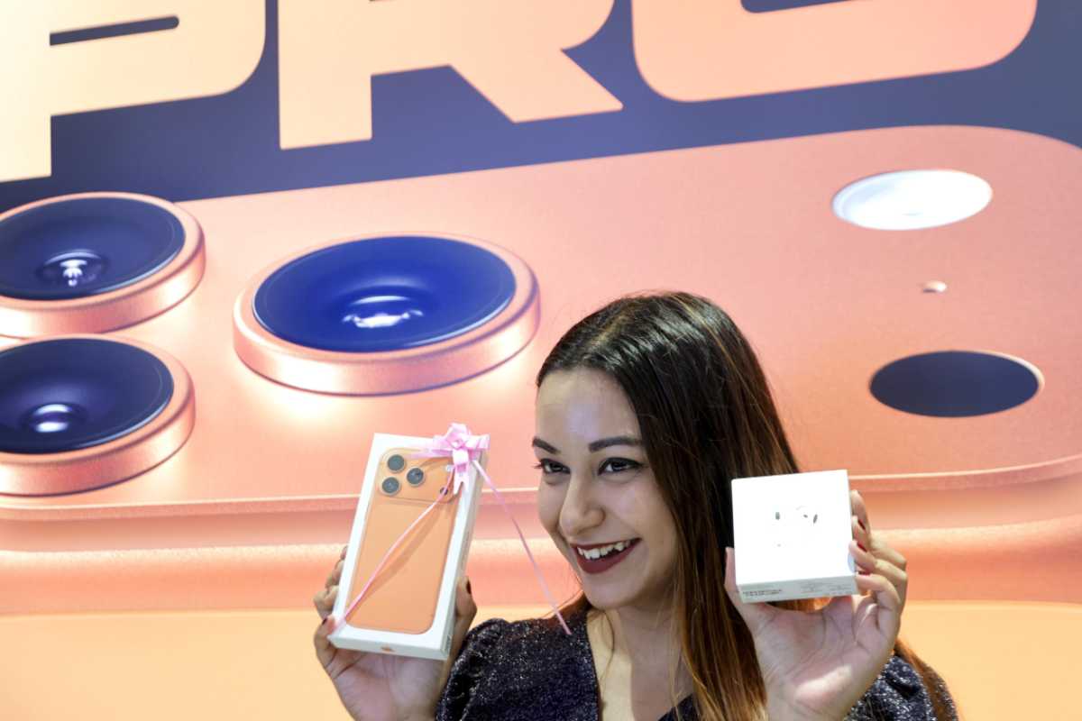 Ragazza sorridente mostra iPhone 17 ed Air Buds