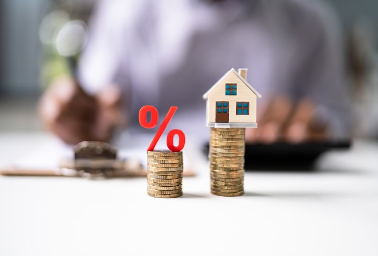 pile di monete e casa in miniatura