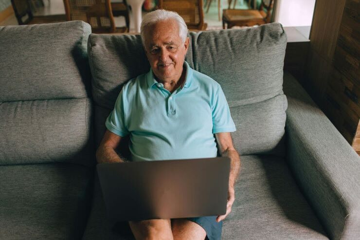 Uomo sul divano con PC 