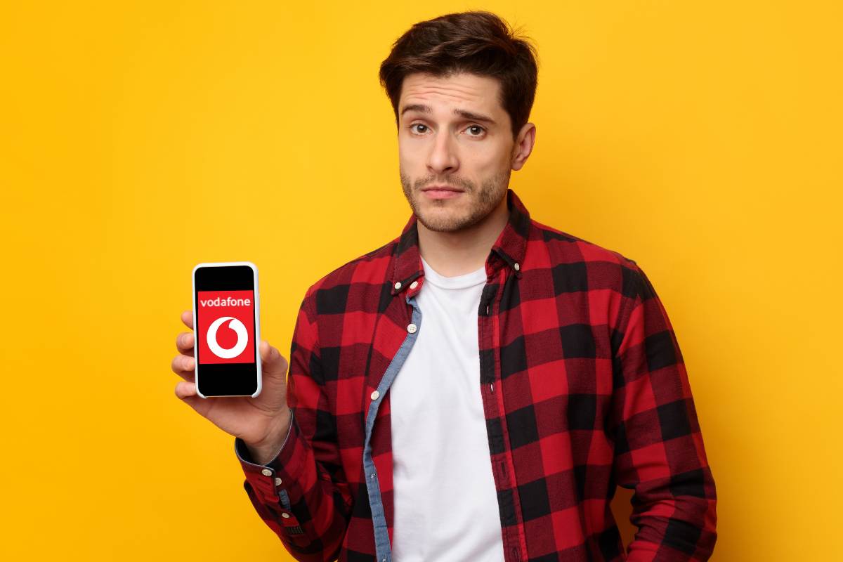ragazzo triste smartphone e logo vodafone
