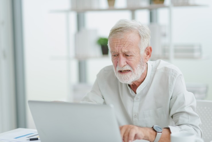 Uomo legge qualcosa al PC