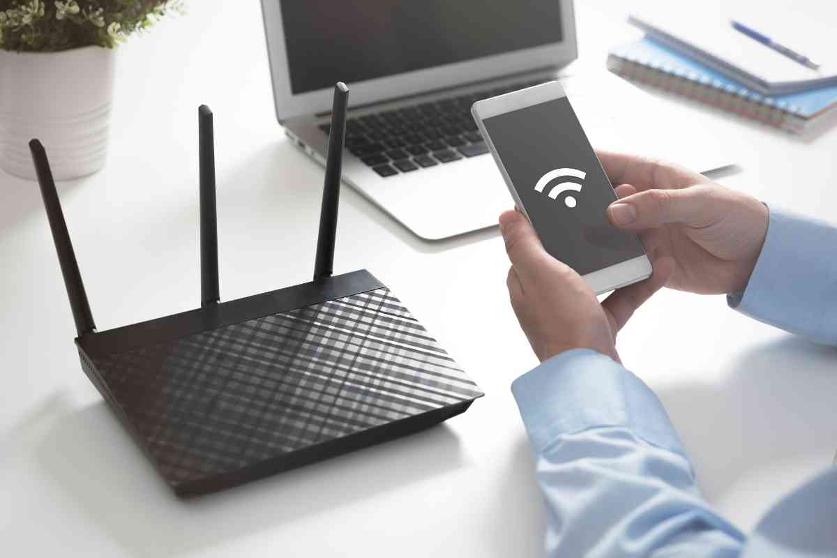 uomo che cerca di connettersi al modem con il cellulare