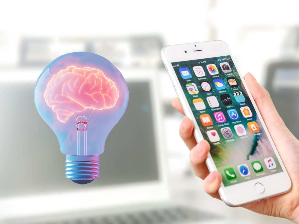 persona che tiene in mano un iphone e accanto c'è una lampadina con dentro un cervello rosa