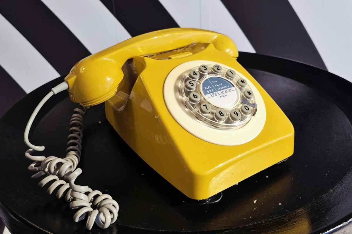 Telefono fisso giallo su tavolino