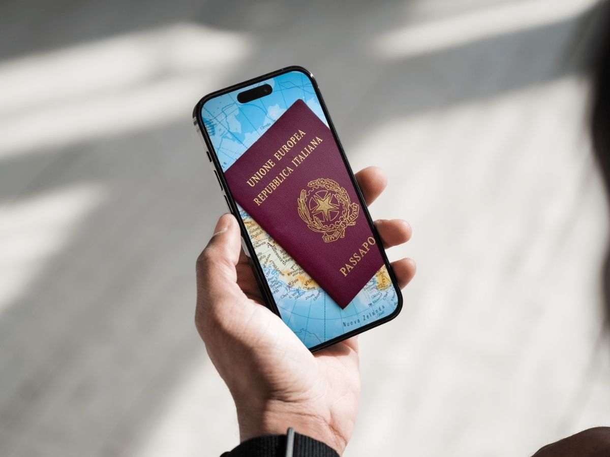 passaporto italiano con mappa sullo schermo di uno smartphone