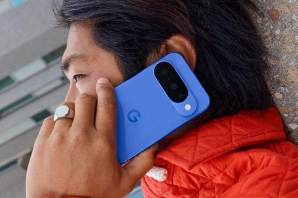 uomo con anelli e giubotto rosso che parla al telefono con pxel 10 blu