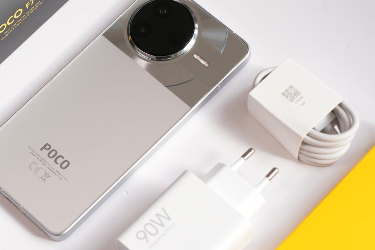 telefono poco steso su tavolo, caricabatterie, cavo