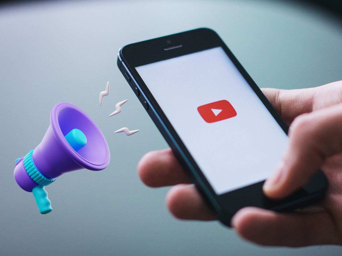 persona che in mano uno smartphone con icona youtube e a fianco un megafono