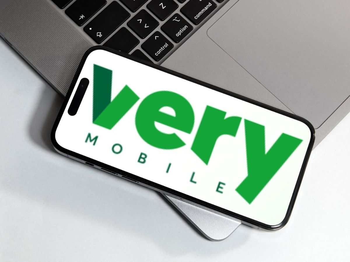 logo very mobile su smartphone appoggiato a un PC portatile